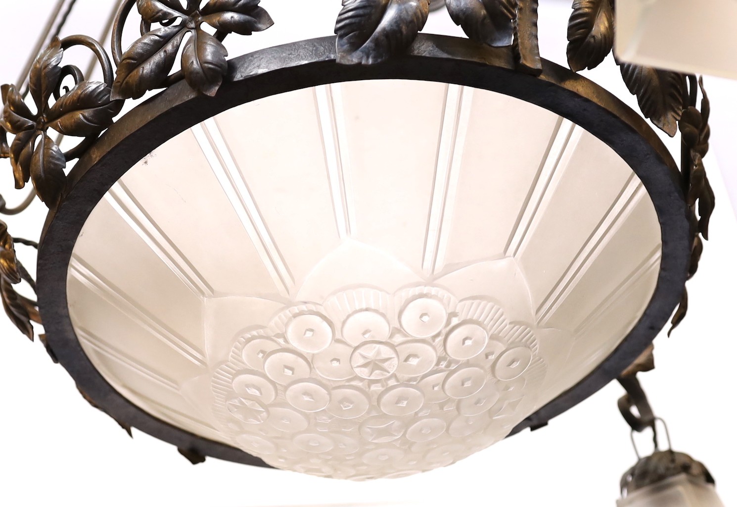 A 1930s French wrought iron and frosted glass light fitting, signed Genet & Michon, height 105cm. width 62cm